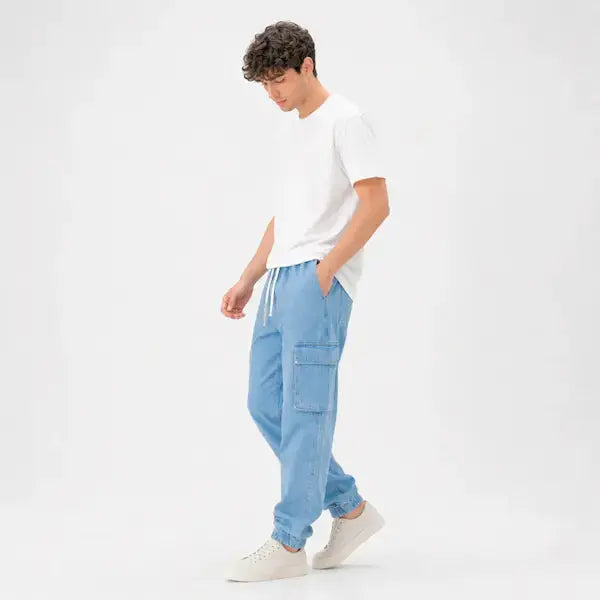 Man wearing KHAAZI denim cargo jogger trouser and white t-shirt