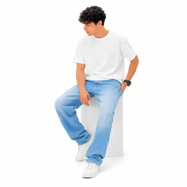 Man wearing KHAAZI light wash denim jeans and white t-shirt
