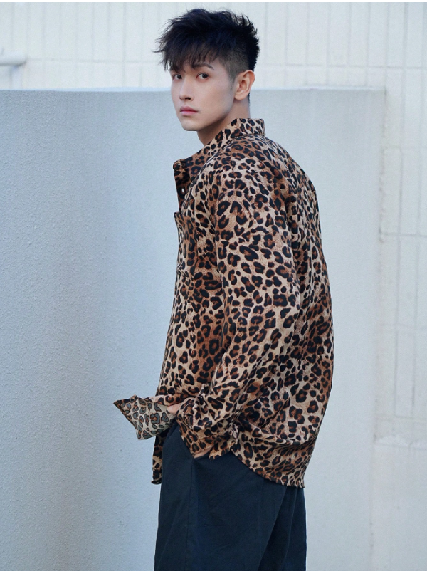 Person wearing a leopard print shirt against a light background