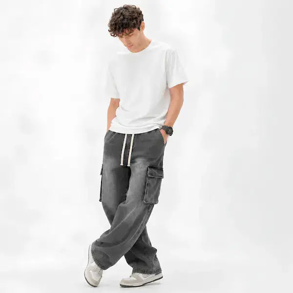 "Grey cargo jeans with drawstring waist and side pocket detail on model"